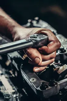 a close shot of hands torquing an engine